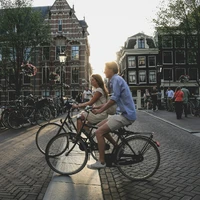 man and woman biking along city at daytime